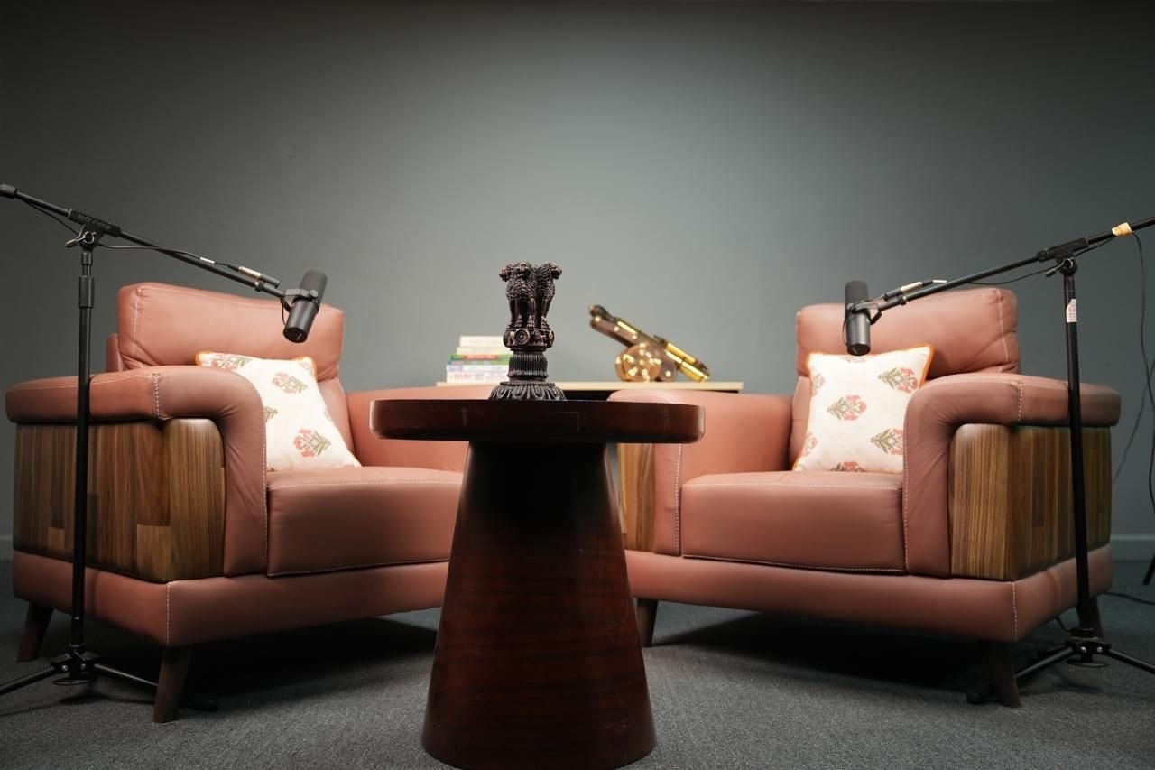 Podcast set with two leather armchairs, cushions and a wooden table